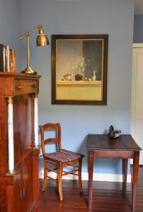 una habitación con una mesa, una silla y una pintura en B&B Gerlachus, en Valkenburg