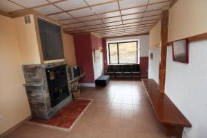 a living room with a fireplace and a couch at Albergue de La Estación del Río Lobos in Hontoria del Pinar