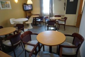 a room with tables and chairs and a tv at IzKaMaGe Hotel in Västerås