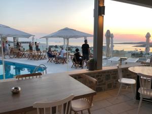 a restaurant with a table and chairs and a pool at Sunset View Hotel in Parikia