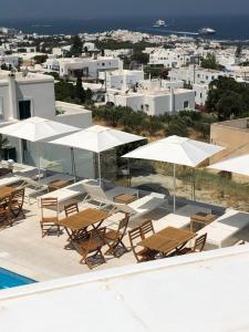 a group of chairs and umbrellas next to a pool at Sunset View Hotel in Parikia