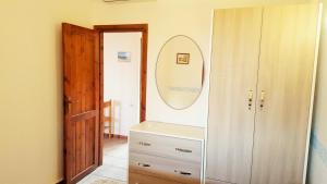 a bathroom with a mirror and a dresser at Villetta Amare Sardegna in Costa Rei