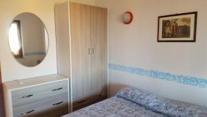 a bedroom with a bed and a mirror and a dresser at Villetta Amare Sardegna in Costa Rei +60 photos