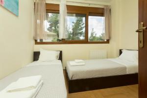 two beds in a room with two windows at Izabella Sea Side Villa in Siviri