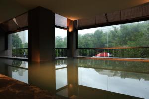 台北市にあるWater Houseのスイミングプールと2つの窓が備わる客室です。