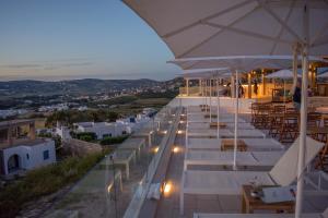 a restaurant with white tables and chairs and lights at Sunset View Hotel in Parikia