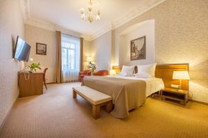 a hotel room with a large bed and a television at Artis Centrum Hotels in Vilnius +41 photos