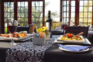 a table with two plates of food and wine glasses at Waterfalls Boutique Hotel in Pretoria