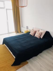 a bedroom with a large black bed with two pillows at Apartament Kolorowy Przy Plazy in Giżycko