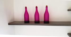 four purple bottles sitting on a shelf at Villa Fotini I in Amalias