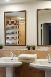 La salle de bains est pourvue de 2 lavabos et d'un grand miroir. dans l'établissement B&B Gerlachus, à Fauquemont