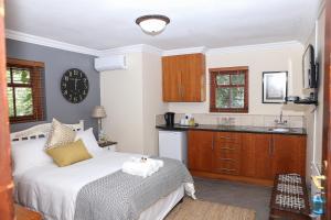 a bedroom with a bed and a kitchen at Angel Oak guesthouse in Brits