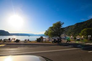 a street with a view of a lake and people on the sidewalk at House Rukavina in Bakarac
