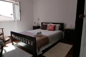 - une chambre avec un lit doté d'oreillers rouges et une fenêtre dans l'établissement Moradia Albertina, à Salgueira