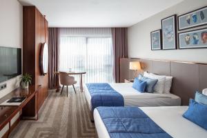 a hotel room with two beds and a television at Lionel Hotel Istanbul in Istanbul +75 photos