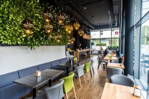 a restaurant with tables and chairs and plants at Seaside Beach 150m do Plaży - Praia Apartments - Polsat Plus Arena in Gdańsk