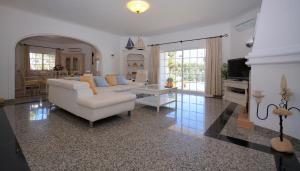 a living room with a white couch and a table at Vila Luz in Vilamoura