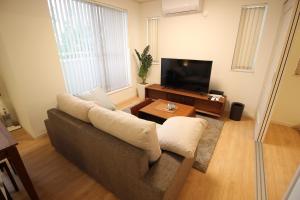 a living room with a couch and a television at HOPE VILLA ONNASON in Onna