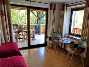 a living room with a table and chairs and a balcony at Domaine de l'Olifant in Champanges