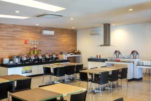 a restaurant with tables and chairs and a counter at Amaris Hotel Pancoran in Jakarta