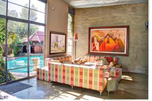 a living room with a couch and a painting on the wall at African Moon Corporate House in Kempton Park
