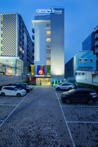 a parking lot with cars parked in front of buildings at Amaris Hotel Pancoran in Jakarta