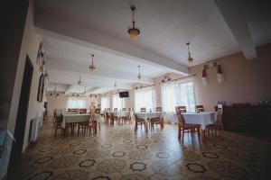 舒加塔格盐矿镇Pensiunea Cosău的一间空荡荡的餐厅，摆着桌椅