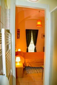 1 dormitorio con cama de color naranja y ventana en In Centro Da Piero - Appartamento In Via Della Viola, en Perugia