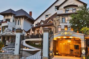 uma casa grande com um portão em frente em VisPas Hotel em Chisinau