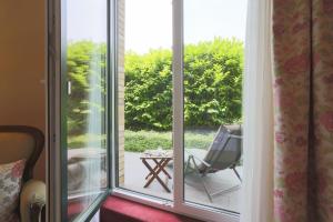a sliding glass door with a chair on a patio at Hotel Gödecke in Sarstedt