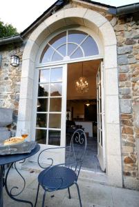 eine Terrasse mit einem Tisch und Stühlen vor einer Tür in der Unterkunft Manoir de la Villeneuve in Lamballe