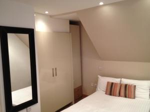 um quarto com um espelho e uma cama em NOX West End Lane I em Londres