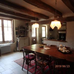 uma cozinha e sala de jantar com uma mesa de madeira e cadeiras em La Pierre qui Parle em Luynes