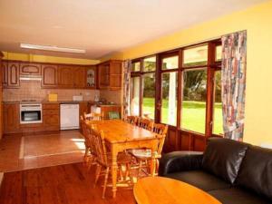 a living room with a table and a kitchen at Gold Coast Resort Dungarvan in Dungarvan