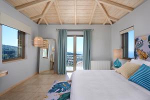 a bedroom with a bed and a large window at Artblue Villas in Tsoukalades +37 photos