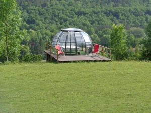 a gazebo with two chairs in a field at Ferme des baillards in Bélesta