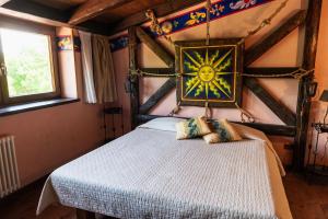 a bedroom with a bed with a painting on the wall at Agriturismo Mezzaluna in Málchina