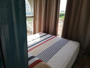 Bett in einem Zimmer mit Blick auf ein Fenster in der Unterkunft Le Sémaphore - studio climatisé, grande terrasse vue mer - parking, wifi in La Grande-Motte