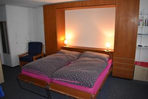 a bedroom with a bed and a blue chair at Ferienwohnung Bündawiese in Davos
