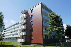 apartamentowiec z balkonem i drzewem w obiekcie CHILLIapartamenty - Bliżej Morza - HYGGE w Kołobrzegu