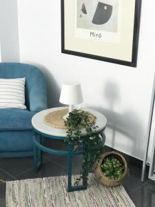 a living room with a blue couch and a table with a lamp at ROOMQUEO-Only Adults in Barbate