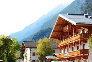 a building with a mountain in the background at Fanky Guided Sport & Outdoor Experience - Hostel & Appartementhaus - Rafting&Canyoning in Haiming