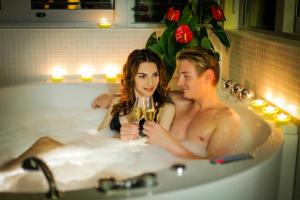 un hombre y una mujer sentados en una bañera en Hotel Veter en Ruše