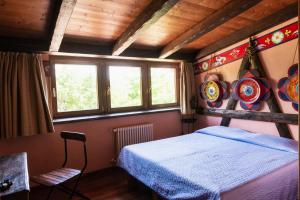 a bedroom with a bed in a room with windows at Agriturismo Mezzaluna in Málchina