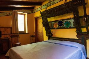 a bedroom with a bed and a mirror on the wall at Agriturismo Mezzaluna in Málchina