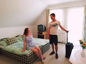 a man and a woman standing in a bedroom at St.Flórián Apartman in Keszthely