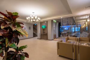 a lobby with couches and a bar in the distance at City Avenue Hotel in Tbilisi City