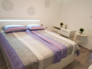 1 dormitorio con 1 cama grande y 2 mesitas de noche en Apartments Stankovo, en Krška Vas