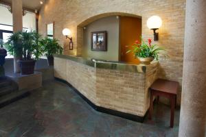 a lobby with a brick wall and potted plants at The Crockett Hotel in San Antonio
