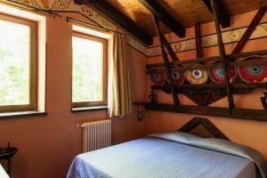 a bedroom with a bed and two windows at Agriturismo Mezzaluna in Málchina